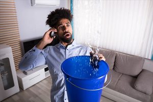 Man catching water leak in apartment